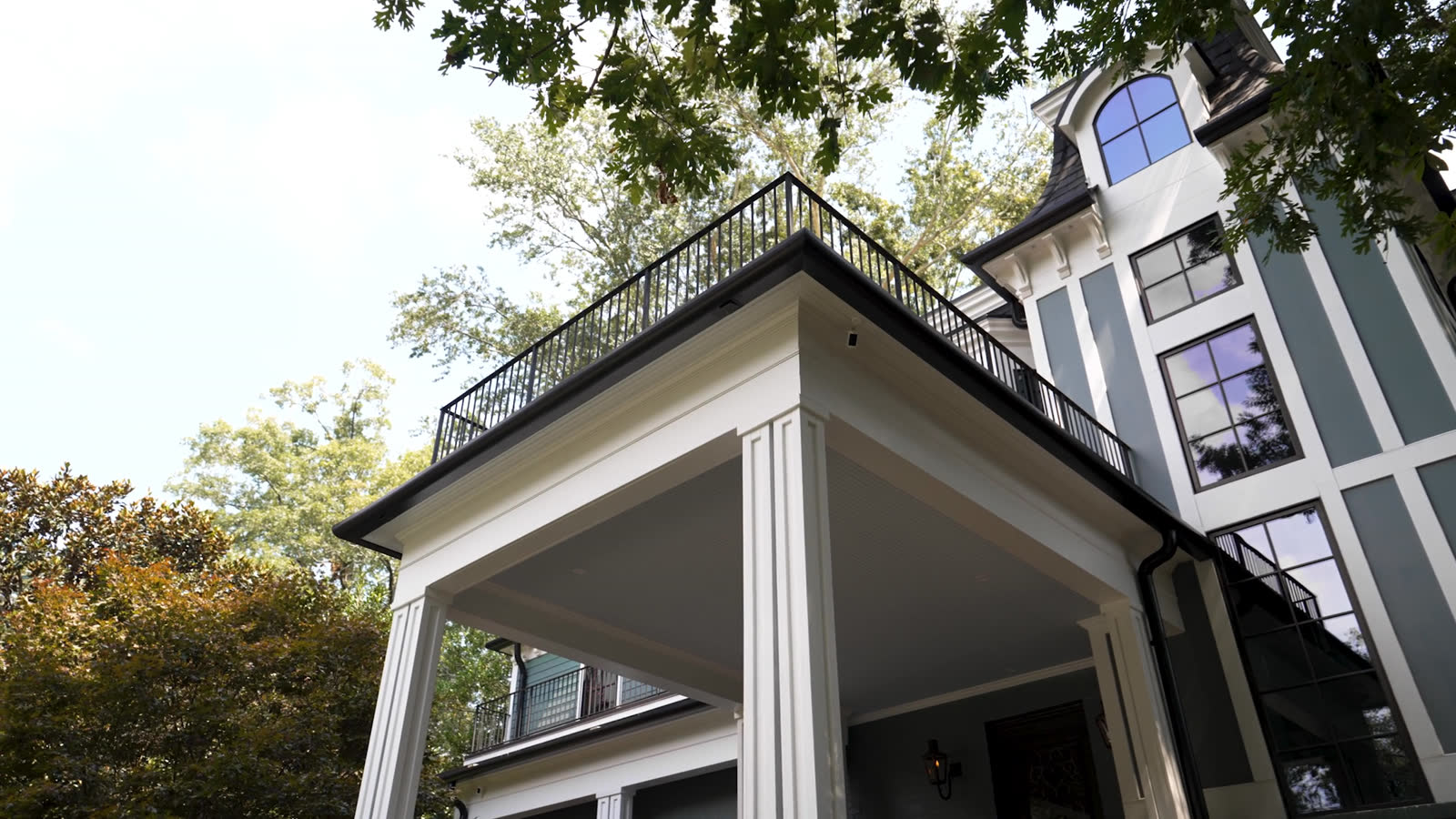 Black gutters finished on a covered porch roofline in West Atlanta