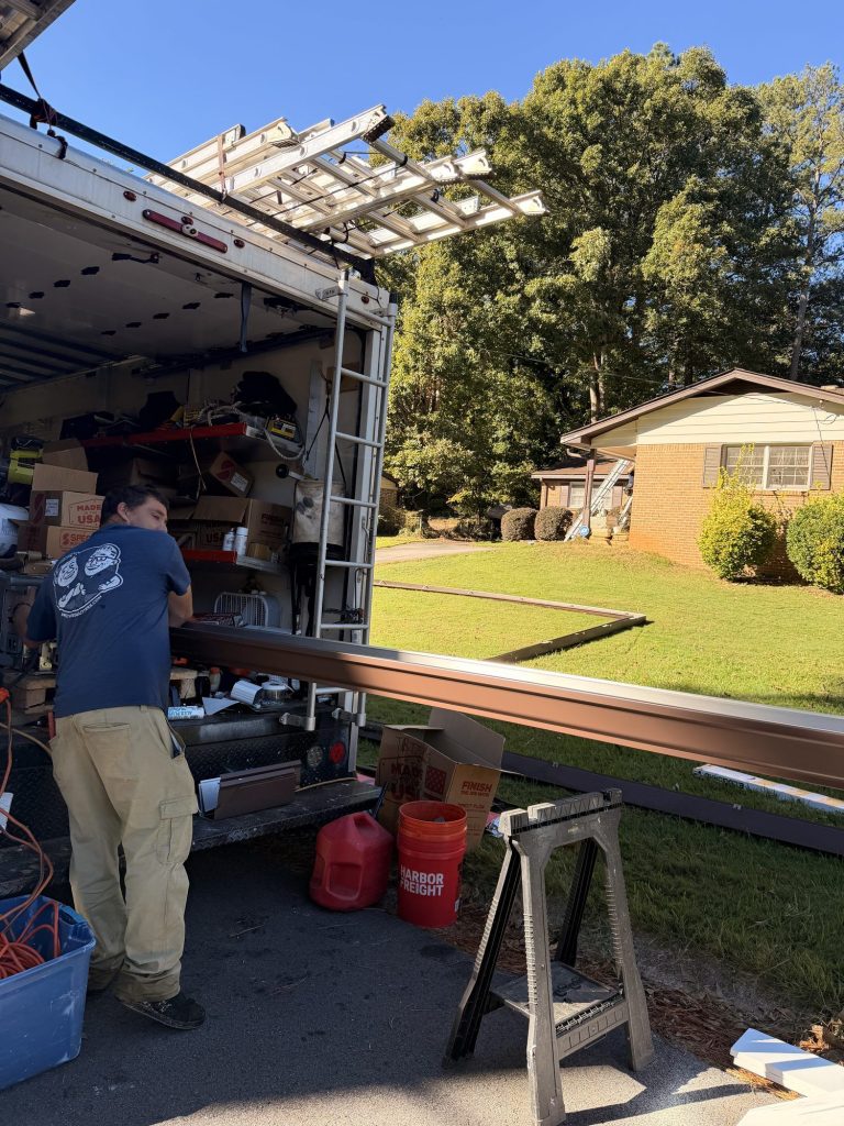 Installer pulling a fresh seamless run from the gutter machine inside the truck in Smyrna