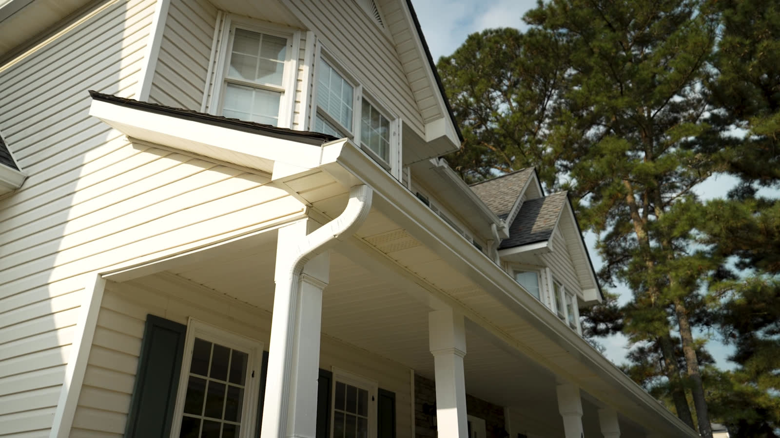 White gutters and downspout on a front porch roofline